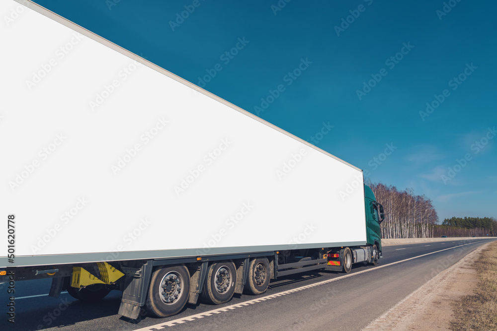 Commercial truck with long empty white board for mock up driving at asphalt road on highway Commercial truck with long empty white board for mock up driving at asphalt road on highway