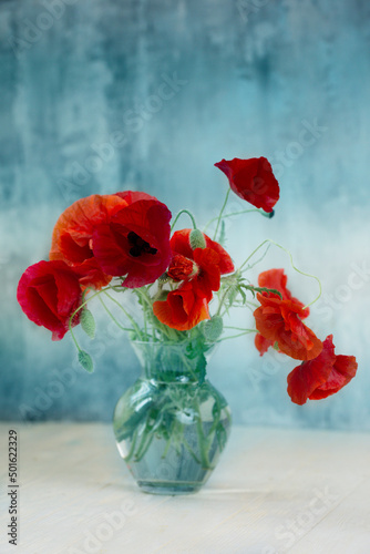 Bouquet of red poppy flowers in glass vase