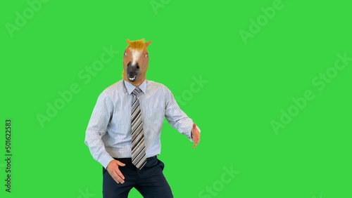 Funny businessman in horse mask dance in office during break to cheer up colleagues at workplace on a Green Screen, Chroma Key.