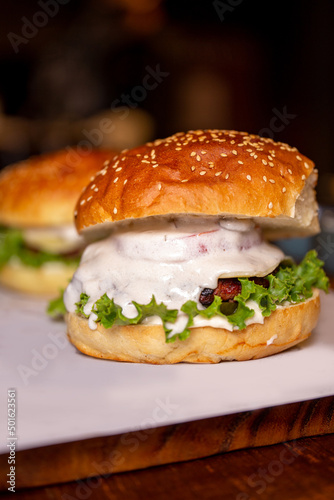 juicy burger with sauce and herbs close-up