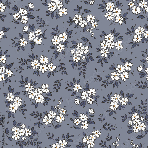 Beautiful floral pattern in small abstract flowers. Small white flowers. Gray blue background. Ditsy print. Floral seamless background. Vintage template for fashion prints. Stock pattern.