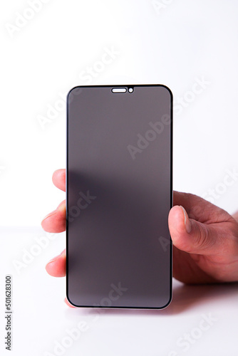 Protective glass for smartphone screen in hand on white background