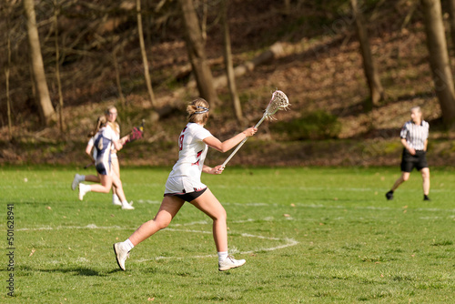 SEWICKLEY, PA, USA - APRIL13th 2022: Teenage girls from Sewickley Academy play senior school varsity lacrosse game against Freeport High School. There were lots of goals and action on this sunny day.