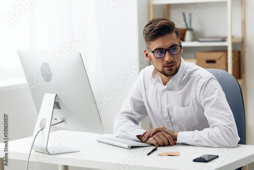 handsome businessman wearing glasses sits at a desk office worked office