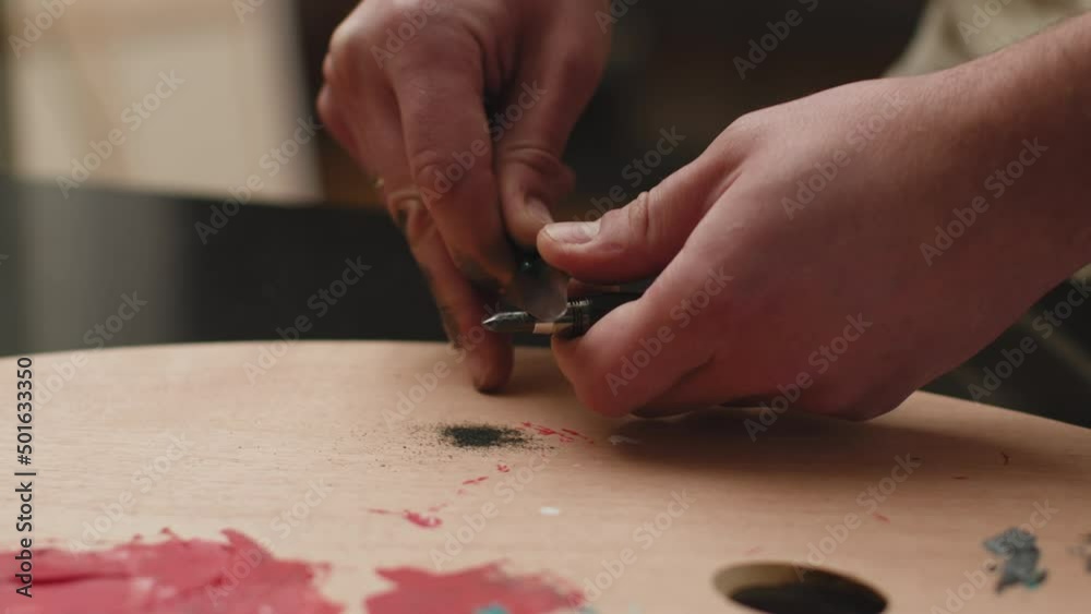 Artist routine. Painter hands sharpening a pencil graphite with cutter knife on wooden palette. Closeup, prores codec Artist routine. Painter hands sharpening a pencil graphite with cutter knife on wooden palette. Closeup, prores codec