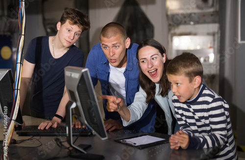 Portrait of a friendly family at a computer  thinking about solving a puzzle in a quest room  stylized as a laboratory