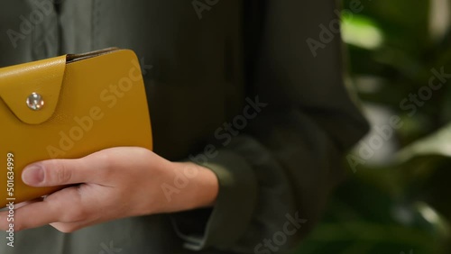 The girl's hands hold a gray purse