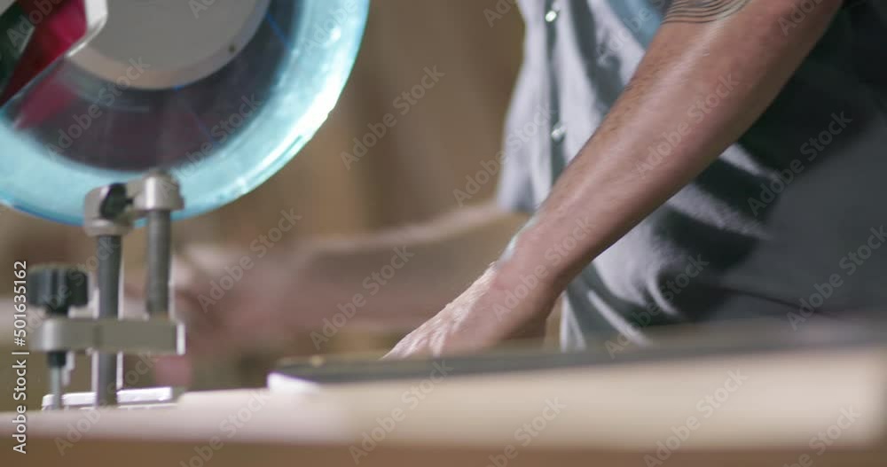 Carpenter works with a table saw to cut wood planks on a construction site Carpenter works with a table saw to cut wood planks on a construction site