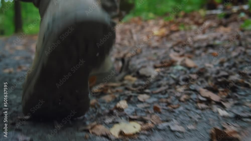 Soldier male legs in army boots walk falls to the ground wounded in camouflage uniform. In forest. Training. Imitation of hostilities