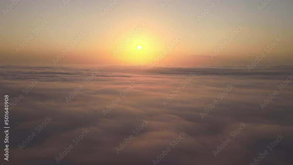 Aerial view from airplane window at high altitude of dense puffy cumulus clouds flying in evening Aerial view from airplane window at high altitude of dense puffy cumulus clouds flying in evening