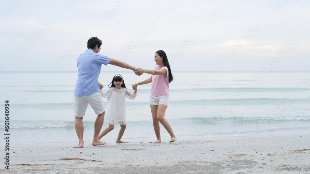 Holiday concept of 4k Resolution. Asian parents and daughters having fun at the beach. summer vacation travel. Holiday concept of 4k Resolution. Asian parents and daughters having fun at the beach. summer vacation travel.