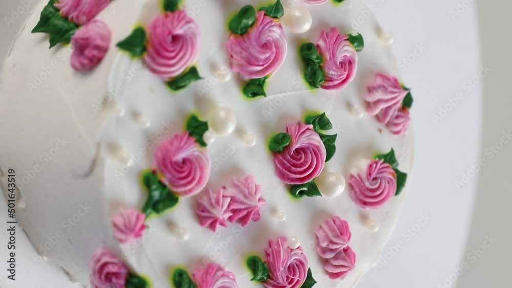 round cake with white cream and and pink roses rotating, side view. vertical footage round cake with white cream and and pink roses rotating, side view. vertical footage
