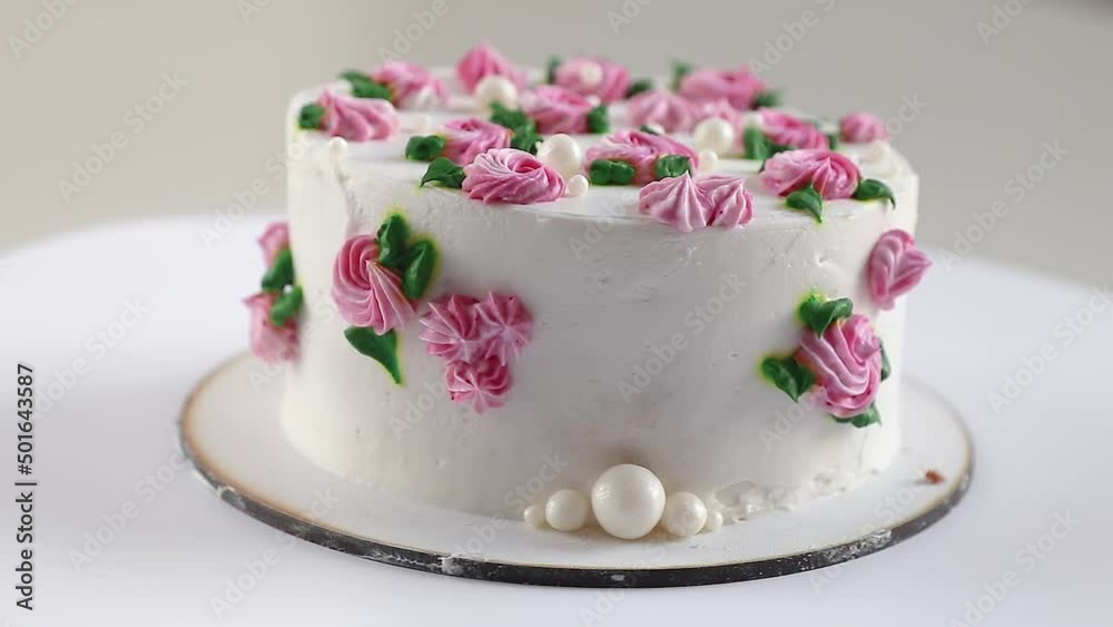 cake with white cream and and pink roses rotating close-up, side view cake with white cream and and pink roses rotating close-up, side view