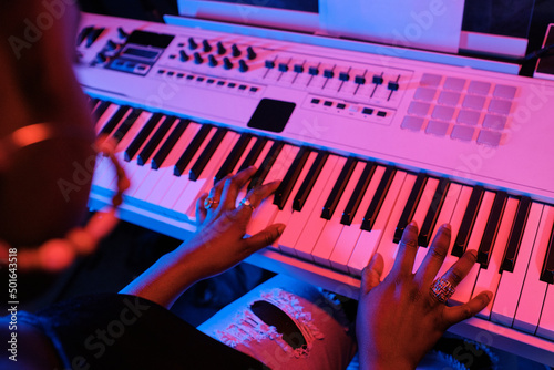 Canvas Print High angle view of unrecognizable young Black woman playing synthesizer in recor