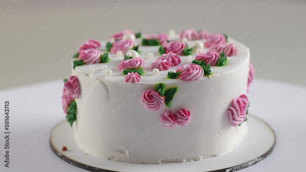 cake with white cream and and pink roses rotating close-up, side view cake with white cream and and pink roses rotating close-up, side view