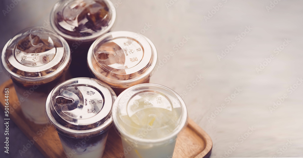 Cold brewed iced latte coffee, Ice coffee latte cup in a plastic glass on. barista hand in coffee cafe.banner background.Cold brew coffee ads.Latte with milk caffeine.plastic ice cup.Arabica roasted. Cold brewed iced latte coffee, Ice coffee latte cup in a plastic glass on. barista hand in coffee cafe.banner background.Cold brew coffee ads.Latte with milk caffeine.plastic ice cup.Arabica roasted.