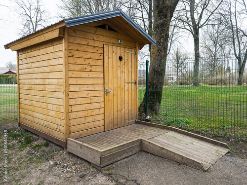 Brown outdoor wooden disabled toilet with heart, Latvia.