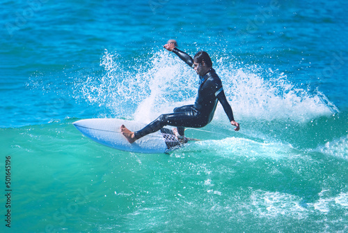 Surfer riding the wave on shortboard. Man catching waves in ocean. Water sports activity