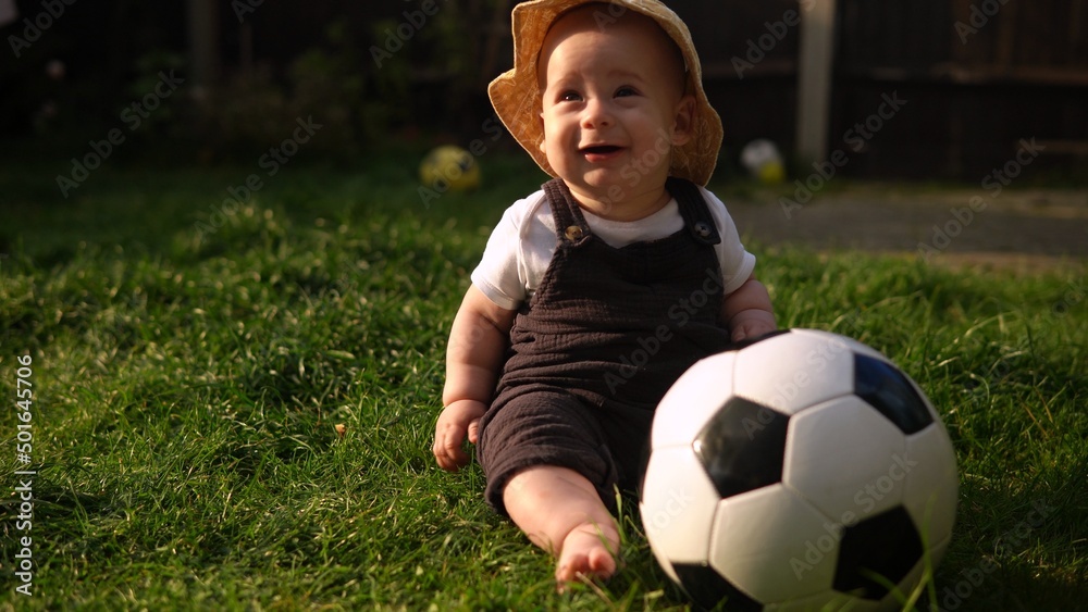 Happy Baby Sitting With Soccer Black White Classic Ball On Green Grass. Adorable Infant Baby Playing Outdoors In Backyard Garden. Little Children With Parents. Football, Championship, Sport Concept