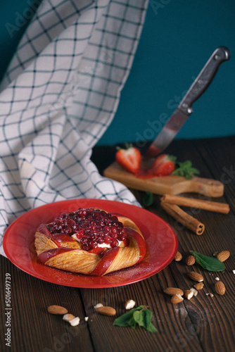 Fresh delicious puff pastry with sweet berries on dark wooden table, closeup