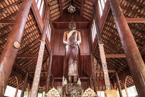 The Wooden Standing Buddha of Wat Luang Khun Win in Chiangmai Province photo