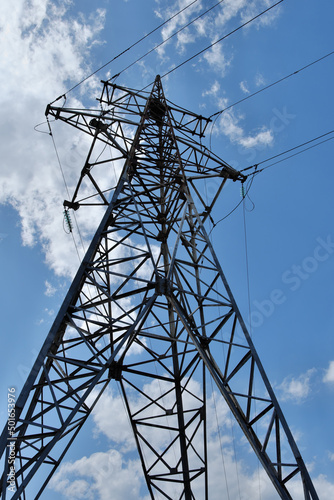 Obraz na plátně A high-voltage metal pylon against a blue cloudy sky.