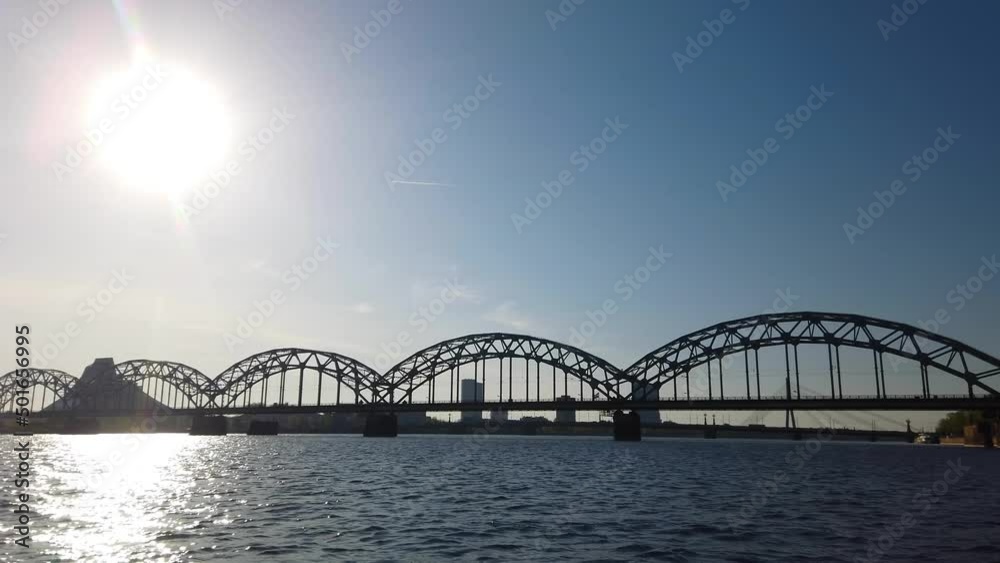Aboard a boat in Riga passing the railway bridge and National Library. Backlit Aboard a boat in Riga passing the railway bridge and National Library. Backlit