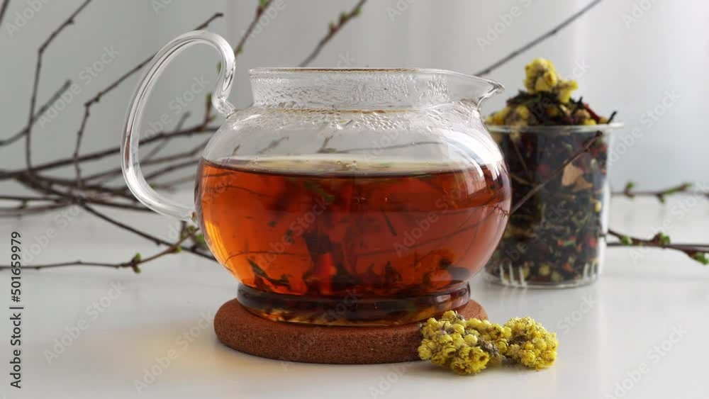 tea with flowers in a transparent glass teapot is brewed in hot water. Pour boiling water into the kettle. Open the tea leaf while brewing. Concept background, slide, composition, tea party still life tea with flowers in a transparent glass teapot is brewed in hot water. Pour boiling water into the kettle. Open the tea leaf while brewing. Concept background, slide, composition, tea party still life