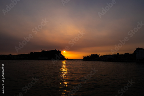 Sunset and sunlight at Kaohsiung harbor, a landscape of mountain with lighthouse and coastline silhouette colorful background in kaohsiung city, Taiwan.
