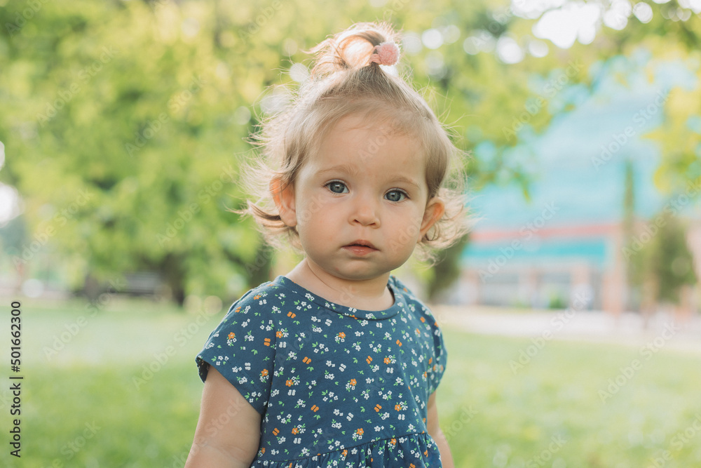 portrait of a cute little girl with blue eyes in a blue dress in the park portrait of a cute little girl with blue eyes in a blue dress in the park