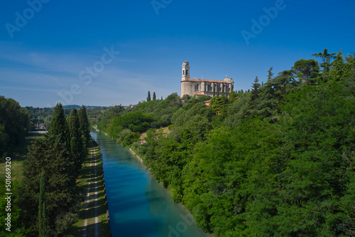 aerial view of the italian church San Michele Church in Monzambano by the river. Church in Italy in a historic town. Historic churches of Italy drone view.