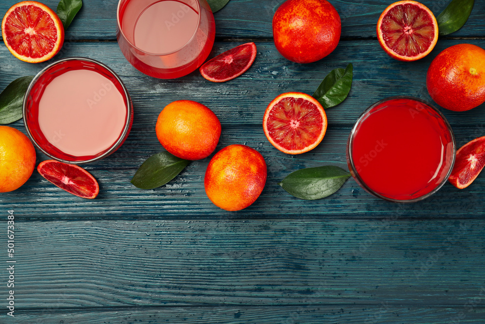 Concept of fresh drink with red orange juice on wooden table Concept of fresh drink with red orange juice on wooden table