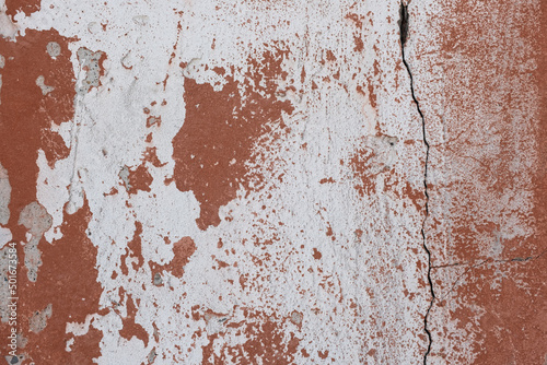 A stone wall with old paint of rough texture and cracks close-up. Background for designers.