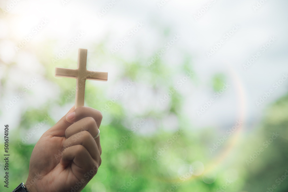 cross on hand nature background Religious and social concepts.