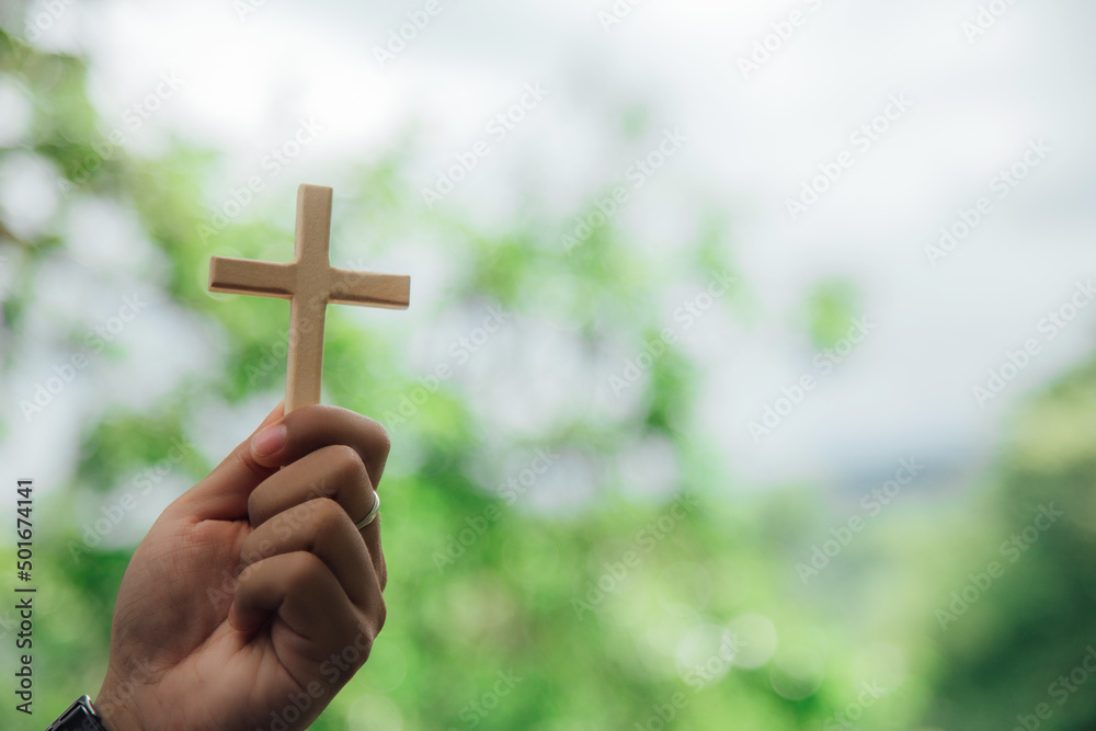 cross on hand nature background Religious and social concepts.