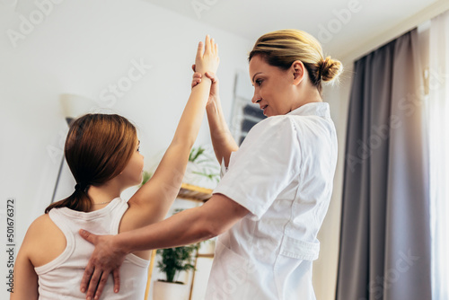 Teen Girl having chiropractic back adjustment. Osteopathy, Physiotherapy, Kinesiology. Bad posture correction