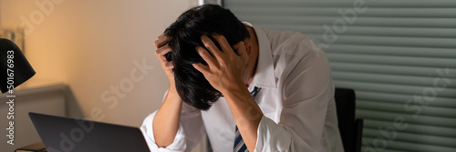 фотографія Overwork Concept The male who works at the office tonight holding his head becau