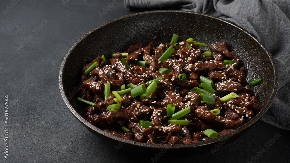 Fototapeta premium Mongolian meat - beef in dark spicy sauce in asian style