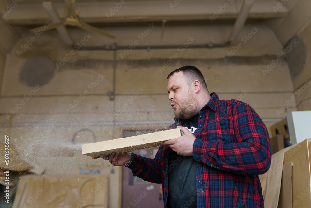 carpenter blowing sawdust off a block of wood carpenter blowing sawdust off a block of wood