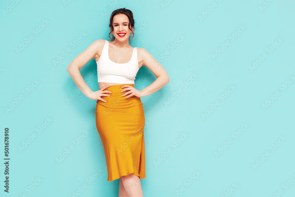 Young beautiful smiling female in trendy summer yellow skirt clothes. Sexy carefree woman posing near wall in studio. Positive model having fun. Cheerful and happy. Isolated Young beautiful smiling female in trendy summer yellow skirt clothes. Sexy carefree woman posing near wall in studio. Positive model having fun. Cheerful and happy. Isolated