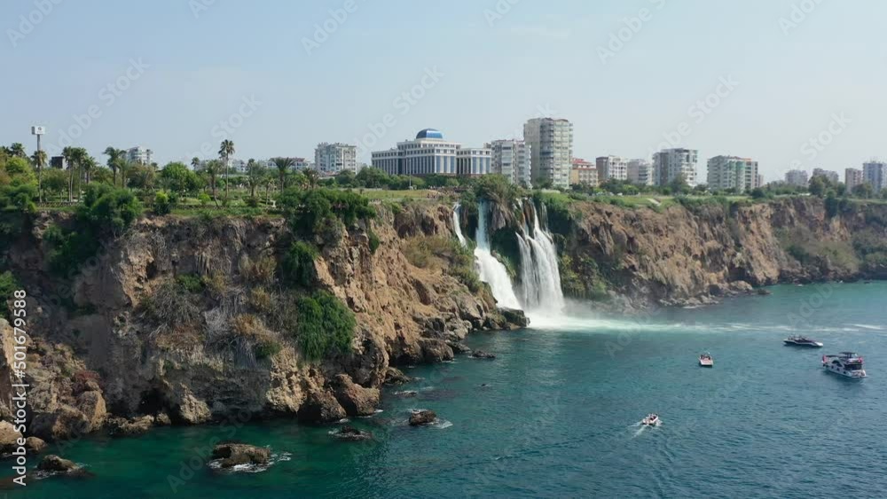 aerial drone of the waters of Lower Duden Waterfall drop off a rocky cliff directly into the Mediterranean Sea in Antalya Turkey as tourist boats view below aerial drone of the waters of Lower Duden Waterfall drop off a rocky cliff directly into the Mediterranean Sea in Antalya Turkey as tourist boats view below