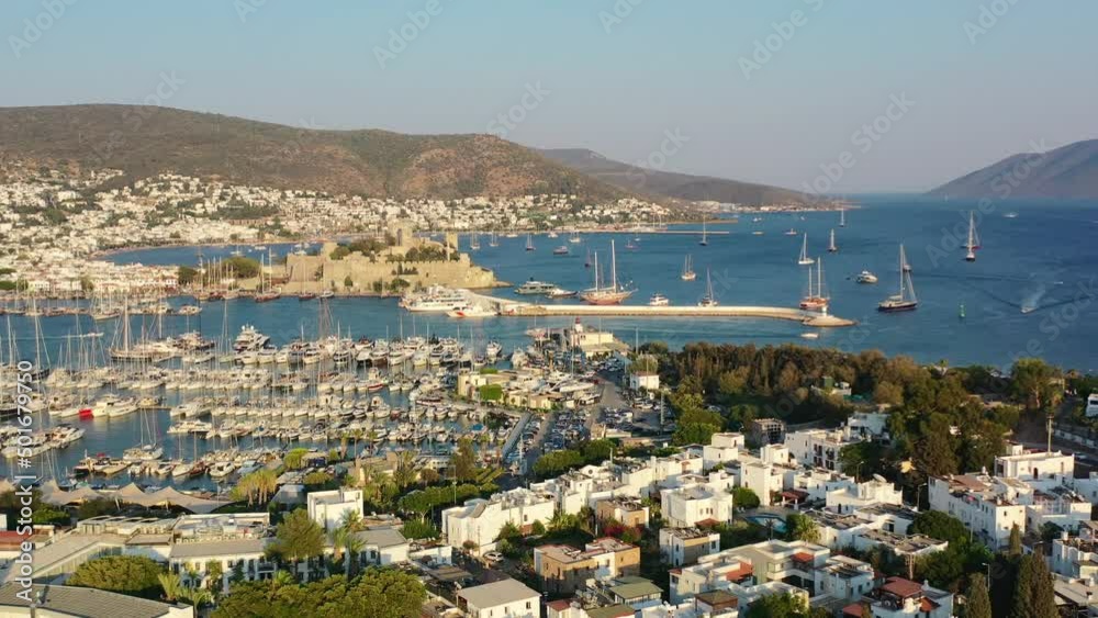 aerial drone revealing the coastal town of Bodrum with a castle and marina full of sailboats in the Aegean Sea of Mugla Turkey on a summer afternoon during sunset aerial drone revealing the coastal town of Bodrum with a castle and marina full of sailboats in the Aegean Sea of Mugla Turkey on a summer afternoon during sunset