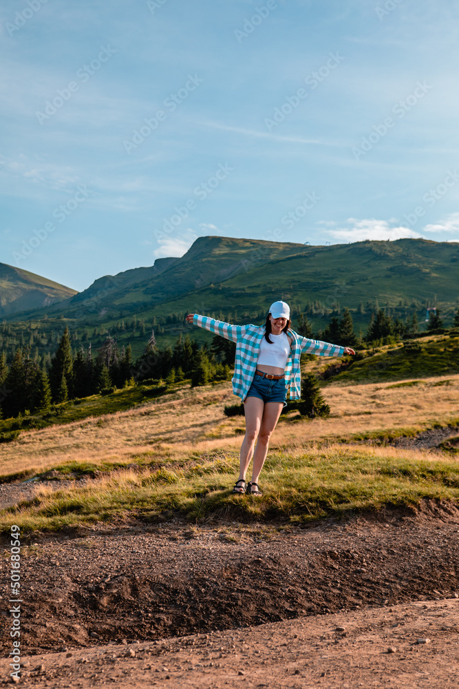 Fototapeta premium woman enjoying sunset above the mountains