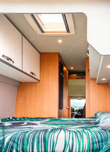 Foto Interior of a camper van with double bed and skylight in the ceiling