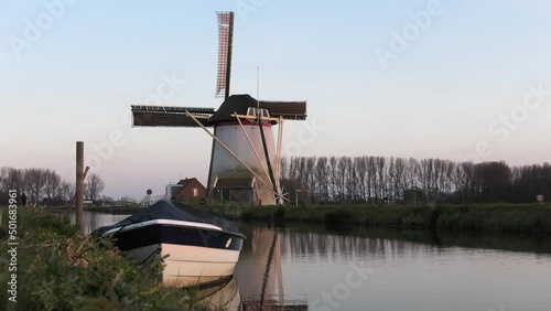 Dutch mill and boat alongside small canal in Schipluiden, the Netherlands photo