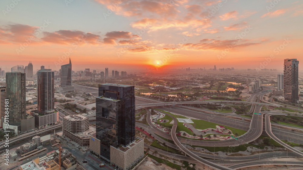 Sunrise over highway junction near media city and al barsha heights district area timelapse from Dubai marina.