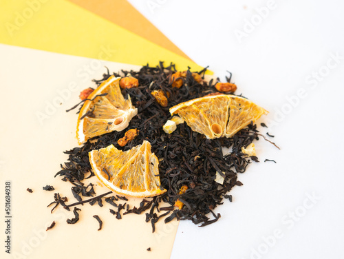 Tea with pieces of dried orange scattered on yellow and orange photo