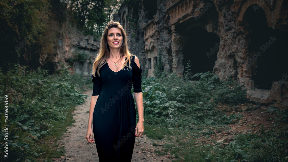 Young woman posing against the background of the ruins of the fortress Young woman posing against the background of the ruins of the fortress