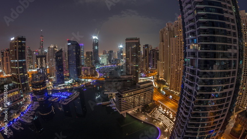 Aerial view to Dubai marina skyscrapers around canal with floating boats night to day timelapse © neiezhmakov