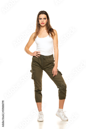 Young woman with three-quarter pants and shirt posing in the studio on white background
